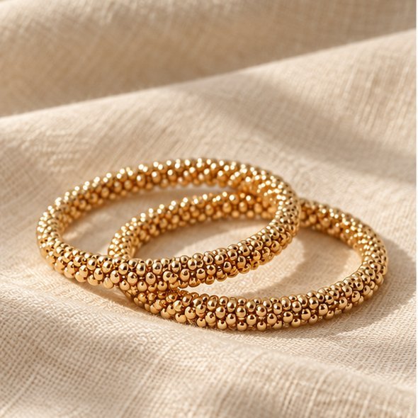Illustration of two gold bracelets on linen