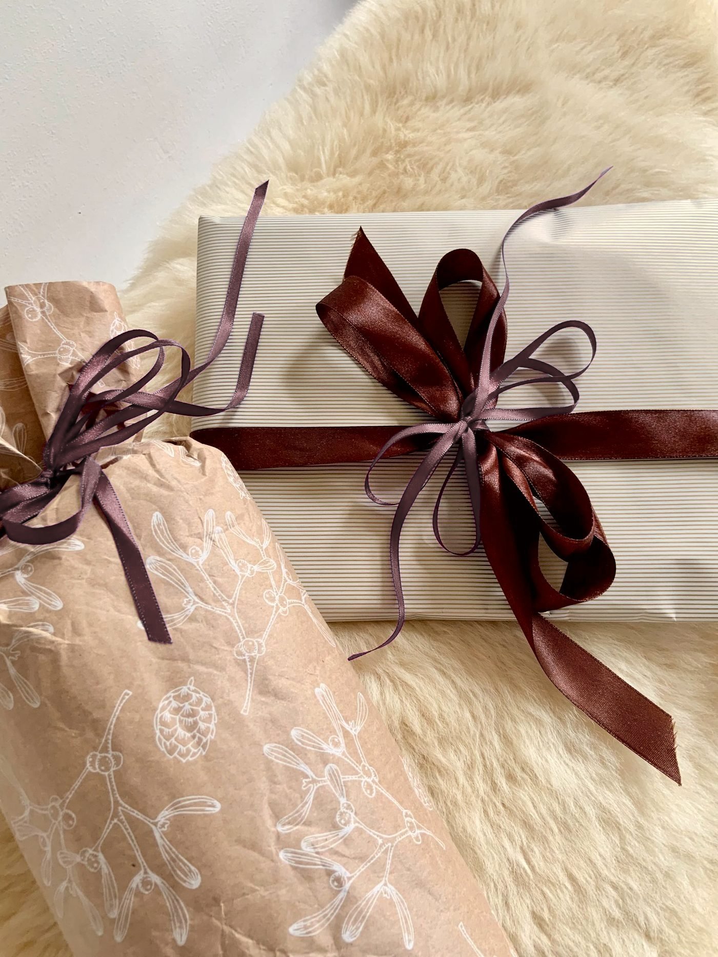 A gift wrapped in cream paper and tied with a burgundy ribbon