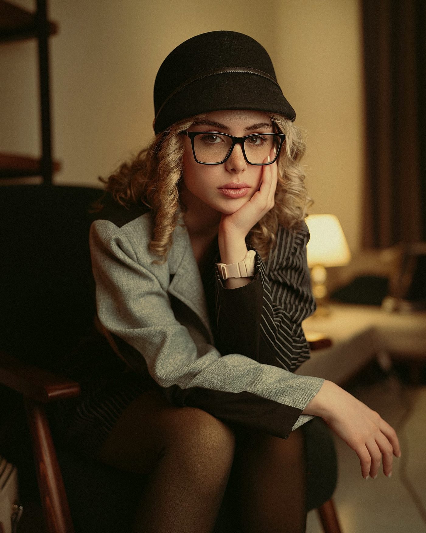A young woman seated in a warm, softly lit interior