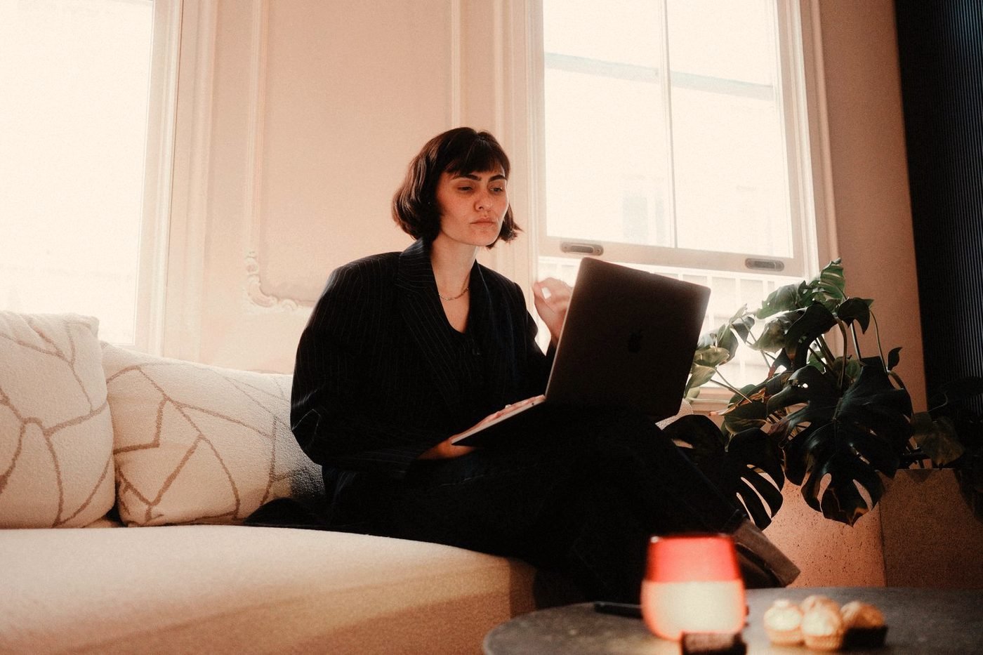 An uncluttered desk with a laptop and notebook in warm light