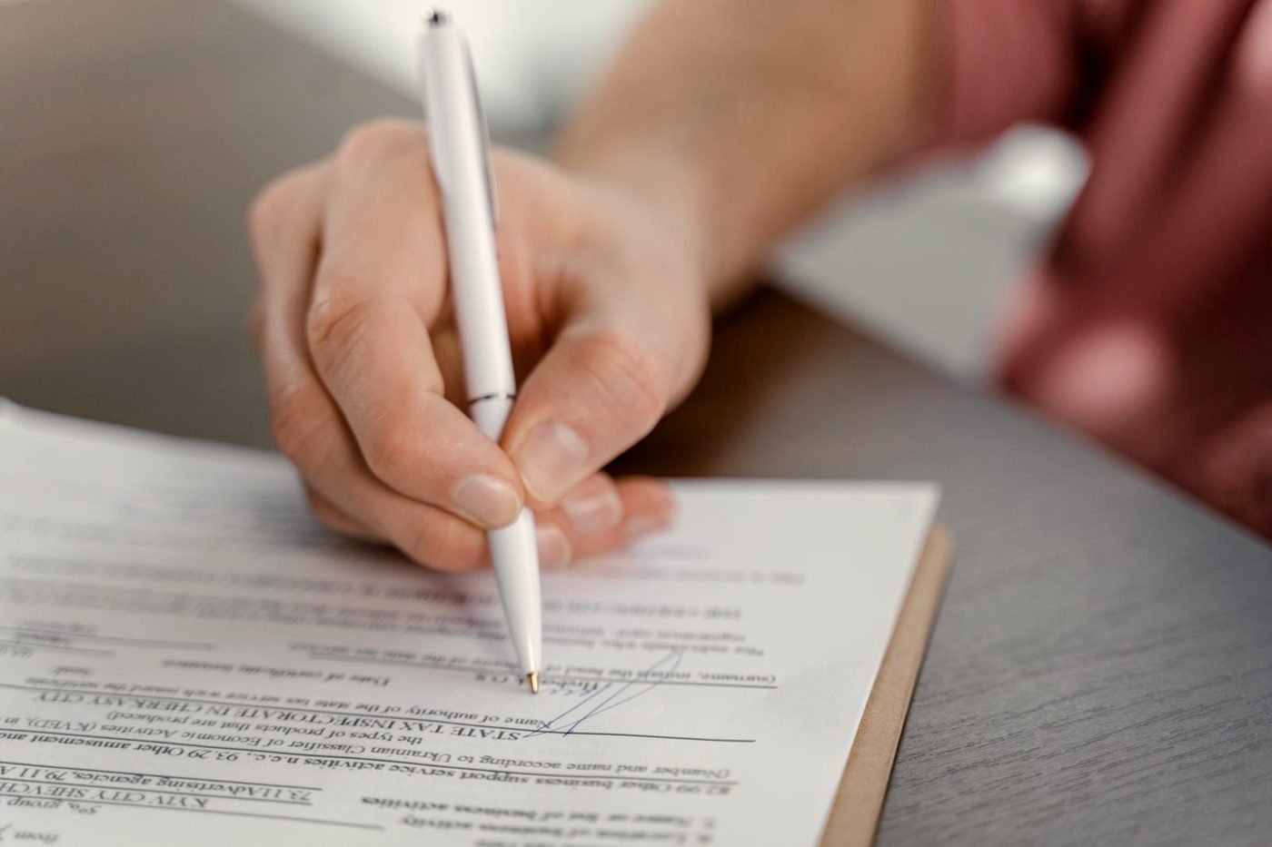 Un escritorio con documentos, boligrafo y cuaderno